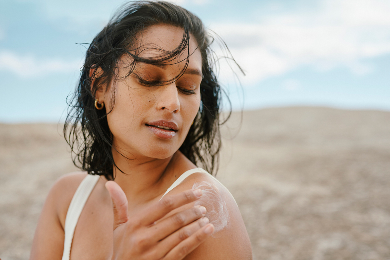 a woman standing on a sandy beach
